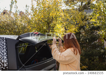 Woman packing luggage into car trunk for road trip Woman packing luggage into car trunk for road trip 140681535