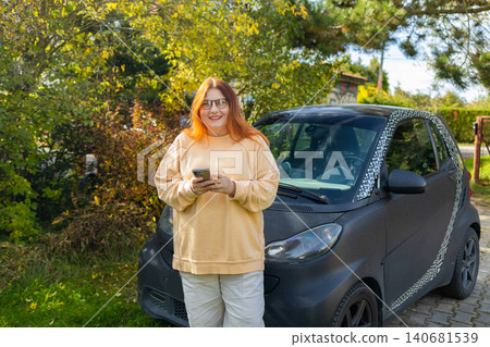 Happy woman with smartphone found signal on road trip near car Happy woman with smartphone found signal on road trip near car 140681539