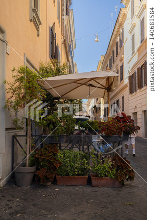 Cozy European street with outdoor cafe terrace and summer flowers Cozy European street with outdoor cafe terrace and summer flowers 140681584