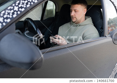 Man using smartphone while sitting in car driver seat Man using smartphone while sitting in car driver seat 140681700