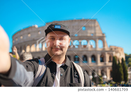 Handsome 30s tourist visiting Colosseum in Rome, Italy. Young man taking photo in front of famous Italian landmark  140681709