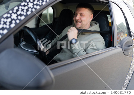 Smiling driver fastening seatbelt inside car before driving Smiling driver fastening seatbelt inside car before driving 140681770