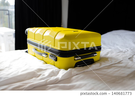 Yellow suitcase on bed in hotel room travel concept Yellow suitcase on bed in hotel room travel concept 140681773