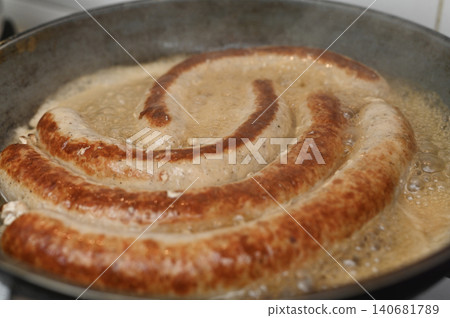 Meat sausages fry in boiling oil inside frying pan. Meat sausages fry in boiling oil inside frying pan. 140681789