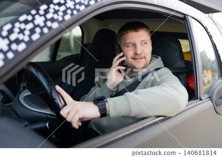 Man talking on phone while driving car looking aside Man talking on phone while driving car looking aside 140681814