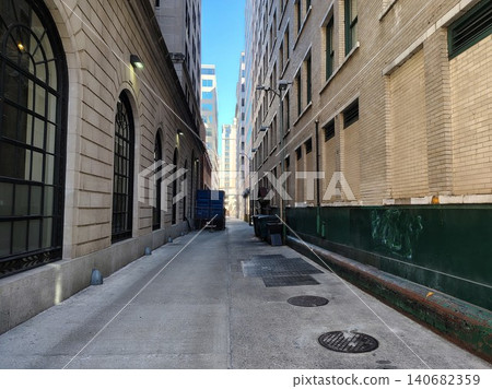 A narrow urban alleyway between tall buildings in downtown Washington, DC, on a clear day. The passage leads to skyscrapers on another street. A narrow urban alleyway between tall buildings in downtown Washington, DC, on a clear day. The passage leads to skyscrapers on another street. 140682359