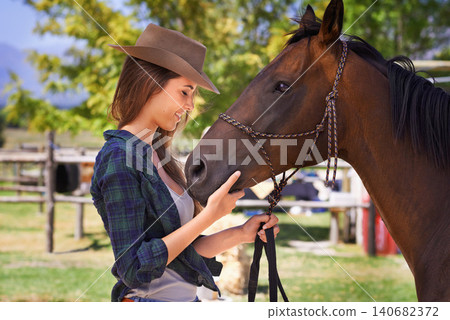 Cowgirl, happy and woman with horse at farm outdoor in summer or nature in Texas for recreation. Western, smile and female person with animal at ranch, pet or stallion in the countryside together Cowgirl, happy and woman with horse at farm outdoor in summer or nature in Texas for recreation. Western, smile and female person with animal at ranch, pet or stallion in the countryside together 140682372