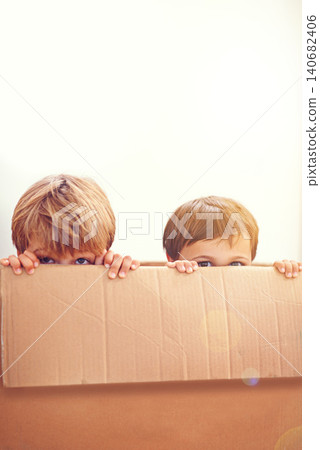 Box, kids and eyes of siblings playing in a house with fun, bonding and hide and seek games. Cardboard, learning and curious boy children in a living room with fantasy, imagine or hiding at home Box, kids and eyes of siblings playing in a house with fun, bonding and hide and seek games. Cardboard, learning and curious boy children in a living room with fantasy, imagine or hiding at home 140682406