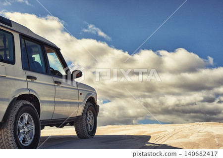 Dunes, vehicle and sky with clouds, adventure and transport on road trip for holiday. Outdoor, sand and 4x4 for travel in Dubai for desert landscape, nature and truck in sunshine and wilderness Dunes, vehicle and sky with clouds, adventure and transport on road trip for holiday. Outdoor, sand and 4x4 for travel in Dubai for desert landscape, nature and truck in sunshine and wilderness 140682417