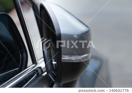 Car side mirror vehicle exterior reflection safety transport closeup, metallic gray automotive mirror on modern sedan door, highlighting design detail, driving visibility, urban street background Car side mirror vehicle exterior reflection safety transport closeup, metallic gray automotive mirror on modern sedan door, highlighting design detail, driving visibility, urban street background 140682776