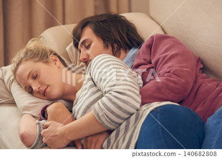 Sleeping, love and couple relax on a sofa with care, support and safety, security and bonding in their home. Peace, calm and people embrace in a living room in comfort, nap or resting in a house Sleeping, love and couple relax on a sofa with care, support and safety, security and bonding in their home. Peace, calm and people embrace in a living room in comfort, nap or resting in a house 140682808
