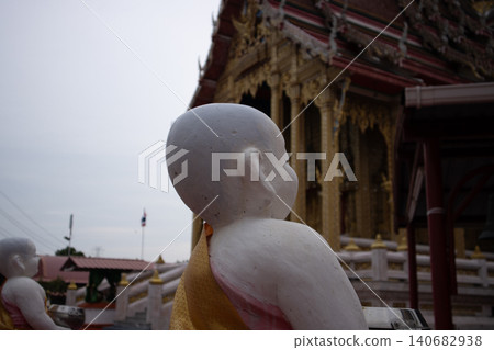 Buddha statue temple Thailand Buddhist architecture shrine monk worship, white figure facing ornate golden facade under cloudy sky, calm spiritual atmosphere, travel culture detail Buddha statue temple Thailand Buddhist architecture shrine monk worship, white figure facing ornate golden facade under cloudy sky, calm spiritual atmosphere, travel culture detail 140682938