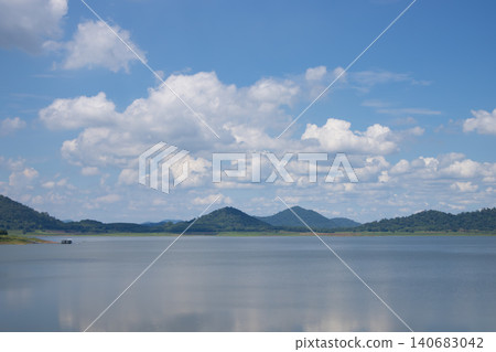 Lake mountain sky cloud water reflection landscape horizon with calm freshwater, distant green ridge, wide blue background, soft daylight, peaceful nature scenery Lake mountain sky cloud water reflection landscape horizon with calm freshwater, distant green ridge, wide blue background, soft daylight, peaceful nature scenery 140683042
