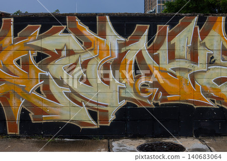 Abstract graffiti mural on concrete wall with orange, beige, black, white street art pattern in urban outdoor setting Abstract graffiti mural on concrete wall with orange, beige, black, white street art pattern in urban outdoor setting 140683064