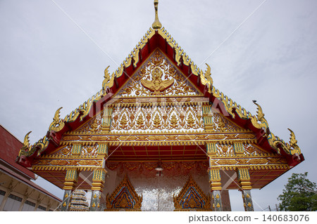Ornate temple roof golden decoration red gable Thai architecture religious building carved pattern sacred place cultural landmark exterior view cloudy sky Ornate temple roof golden decoration red gable Thai architecture religious building carved pattern sacred place cultural landmark exterior view cloudy sky 140683076