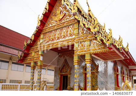Ornate temple entrance with golden decoration, red roof, and carved gable in traditional asian shrine Ornate temple entrance with golden decoration, red roof, and carved gable in traditional asian shrine 140683077