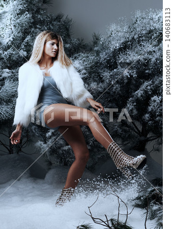 Fashion, studio and woman by tree for winter style, confidence and fur coat with underwear. Serious face, female person and kicking snow with boots for trendy clothes, jacket and feminine glamour Fashion, studio and woman by tree for winter style, confidence and fur coat with underwear. Serious face, female person and kicking snow with boots for trendy clothes, jacket and feminine glamour 140683113