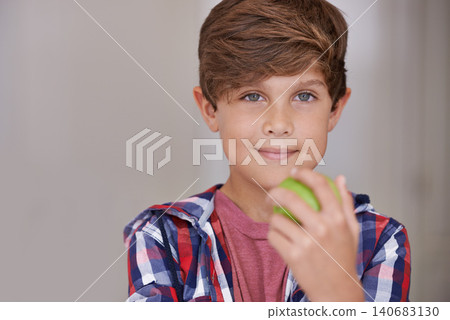 Portrait, apple and boy child in home, eating green fruit as diet, health or nutrition for development. Face, food and natural with confident young teen kid holding organic produce in apartment Portrait, apple and boy child in home, eating green fruit as diet, health or nutrition for development. Face, food and natural with confident young teen kid holding organic produce in apartment 140683130