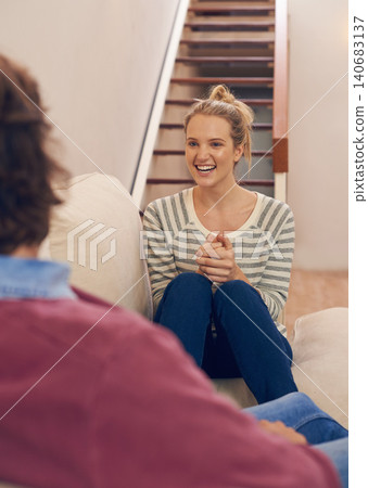 Love, couple and bonding on a sofa with chat, conversation or sharing gossip in their home. Trust, support and woman person in a living room excited about story, communication or chilling in a house Love, couple and bonding on a sofa with chat, conversation or sharing gossip in their home. Trust, support and woman person in a living room excited about story, communication or chilling in a house 140683137