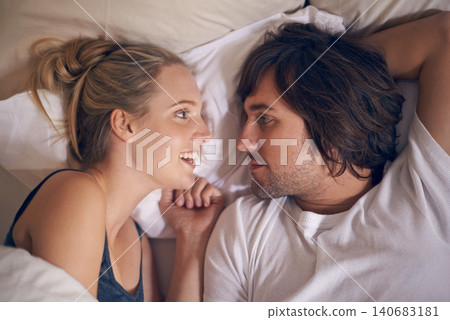 Love, relax and couple in a bed talking, bonding and resting in their home from above. Wake up, conversation and people in a bedroom with morning speaking, chat or chilling in a house on weekend 140683181