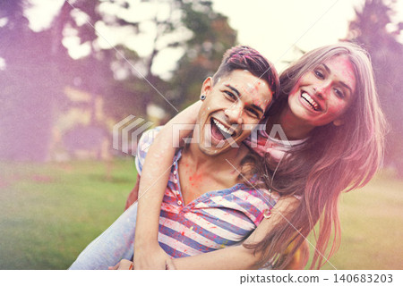 Happy, powder paint and couple of friends hug at Holi festival and colorful event with smile. Celebration, love and excited in nature with hipster people and crazy color dust for party together 140683203