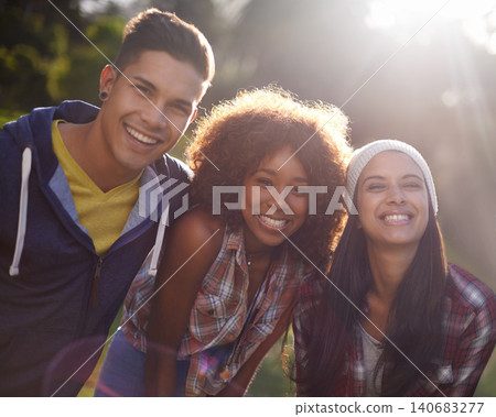 Portrait, smile and diversity student in nature, happy and excited in garden or outside. Face, sunshine and joy in summer at sunset with lens flare, bonding and social on getaway with learner friends 140683277