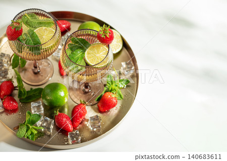 Refreshing strawberry mojito cocktails on golden tray Refreshing strawberry mojito cocktails on golden tray 140683611