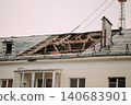 Roof renovation site with concrete slabs and construction materials near residential building 140683901