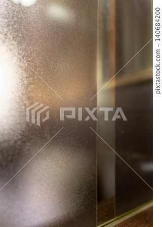 Beautiful city lights and a bokeh texture background, seen through frosted glass. 140684200
