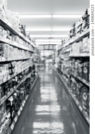 A blurred, monochrome image of a supermarket aisle. 140684225