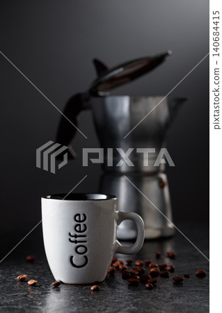 Cup of espresso and classic Italian aluminium moka pot on a black background. 140684415