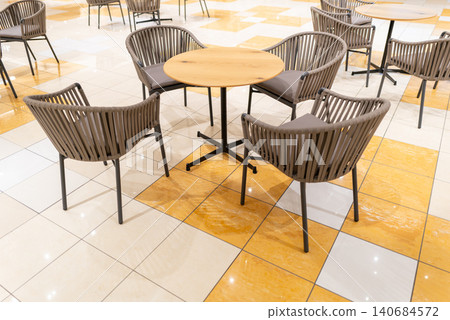 Bright cafe tables and chairs inside a commercial facility Bright cafe tables and chairs inside a commercial facility 140684572
