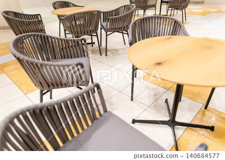 Bright cafe tables and chairs inside a commercial facility Bright cafe tables and chairs inside a commercial facility 140684577
