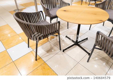 Bright cafe tables and chairs inside a commercial facility Bright cafe tables and chairs inside a commercial facility 140684579