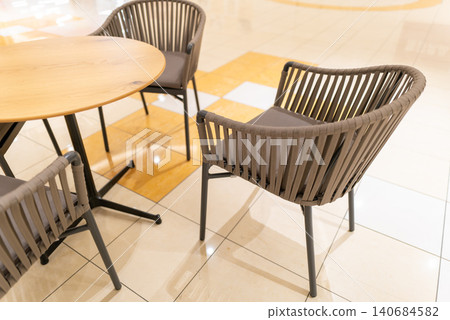 Bright cafe tables and chairs inside a commercial facility Bright cafe tables and chairs inside a commercial facility 140684582