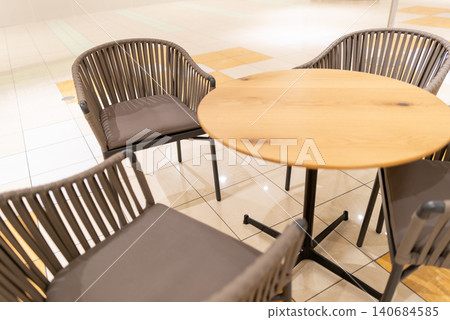 Bright cafe tables and chairs inside a commercial facility Bright cafe tables and chairs inside a commercial facility 140684585