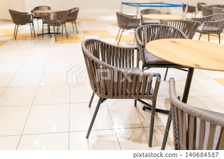 Bright cafe tables and chairs inside a commercial facility Bright cafe tables and chairs inside a commercial facility 140684587