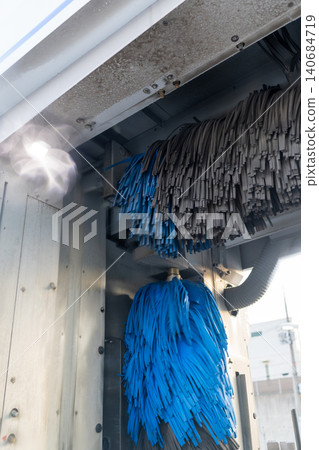 A scene of a car being washed by an automatic car wash machine at a gas station. A scene of a car being washed by an automatic car wash machine at a gas station. 140684719