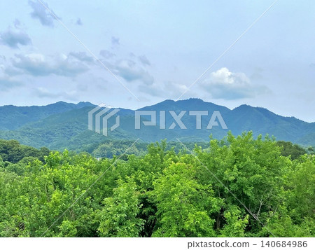 A landscape of lush green mountains and trees in early summer. A landscape of lush green mountains and trees in early summer. 140684986