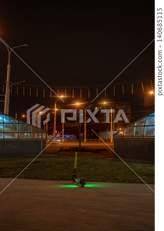 Minsk night e scooter on brick walkway by glass domed subway 140685115