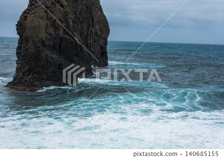 Madeira basalt sea cliff with Atlantic waves under an overcast sky Madeira basalt sea cliff with Atlantic waves under an overcast sky 140685155