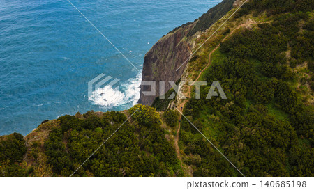 Aerial coastal cliff and hikers on Madeira, Portugal, Atlantic surf Aerial coastal cliff and hikers on Madeira, Portugal, Atlantic surf 140685198