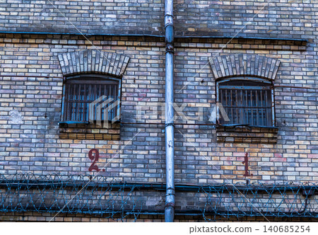 Weathered brick wall with barred arched windows at Lukiskes Prison Weathered brick wall with barred arched windows at Lukiskes Prison 140685254