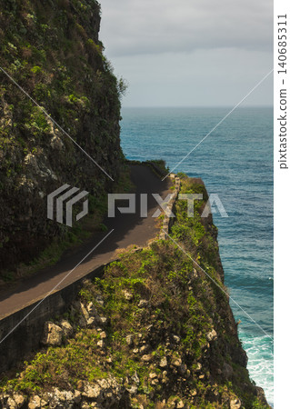 Coastal road on Madeira clings to rugged cliffs above the Atlantic 140685311