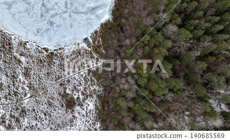 Aerial View of Frozen Lake and Forest with Path in Winter Aerial View of Frozen Lake and Forest with Path in Winter 140685569