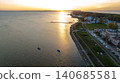 Sunset Over Lakeside with Pier, Boats, and Residential Area 140685581
