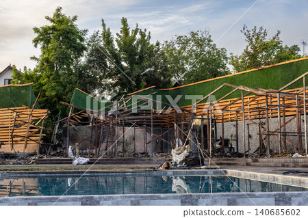 Bila Tserkva, Kyiv region, Ukraine - 09.06.2025: Destroyed outdoor recreation area next to swimming pool with burnt wooden gazebos collapsed fences and debris after explosion or fire accident Bila Tserkva, Kyiv region, Ukraine - 09.06.2025: Destroyed outdoor recreation area next to swimming pool with burnt wooden gazebos collapsed fences and debris after explosion or fire accident 140685602