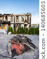 Bila Tserkva, Kyiv region, Ukraine - 09.06.2025: Modern hotel building ruined by fire explosion with burnt charred facade empty windows sandbags and pile of debris in courtyard outside 140685603