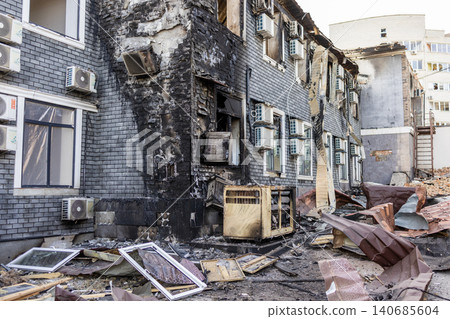 Bila Tserkva, Kyiv region, Ukraine - 09.06.2025: Facade of destroyed city building with charred brick walls, broken windows, damaged air conditioners and debris after fire explosion Bila Tserkva, Kyiv region, Ukraine - 09.06.2025: Facade of destroyed city building with charred brick walls, broken windows, damaged air conditioners and debris after fire explosion 140685604
