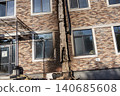 Bila Tserkva, Kyiv region, Ukraine - 09.06.2025: Name Facade of modern brick building damaged by fire and explosion with charred wall shattered window glass and destroyed utility pipe outside 140685608